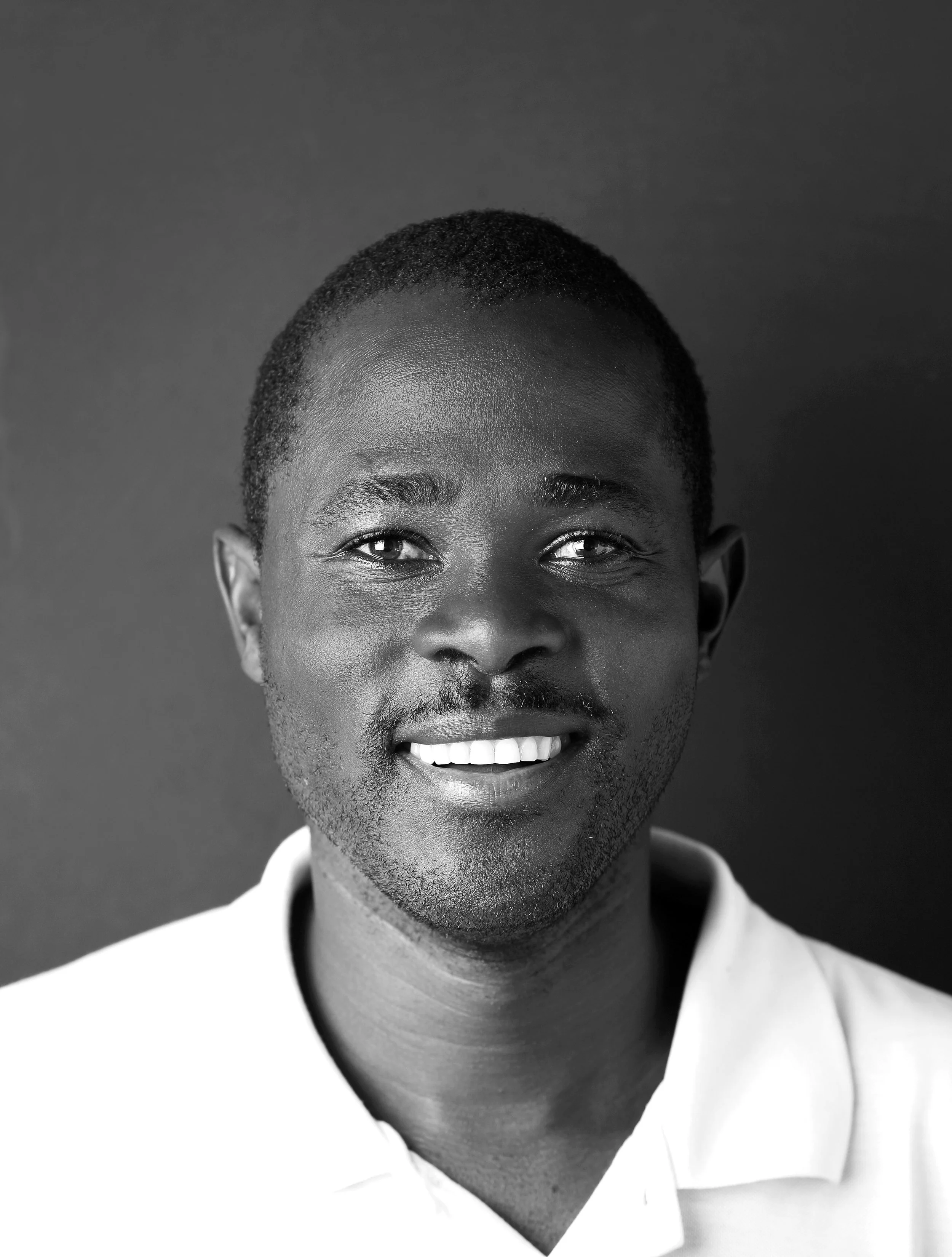 Cry Sithole — studio portrait, black and white, warm direct gaze.