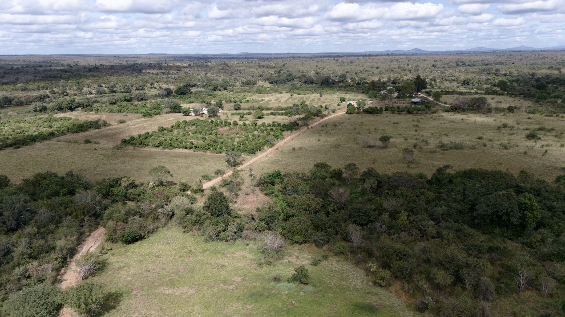 Aerial view across the Sand catchment landscape — mixed bushveld, smallholder plots and distant ridges that the Save the Sand restoration programme operates inside, May 2026.