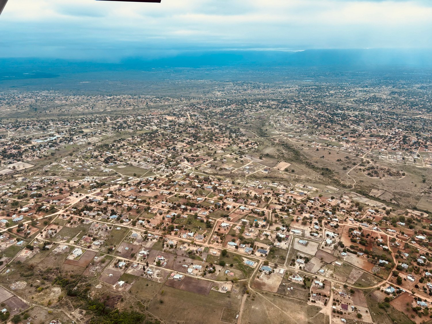 Aerial of Jongilanga Traditional Authority — dense rural homesteads, sand roads, and cropland fanning out toward the bushveld horizon. The landscape where Phase 1 begins.